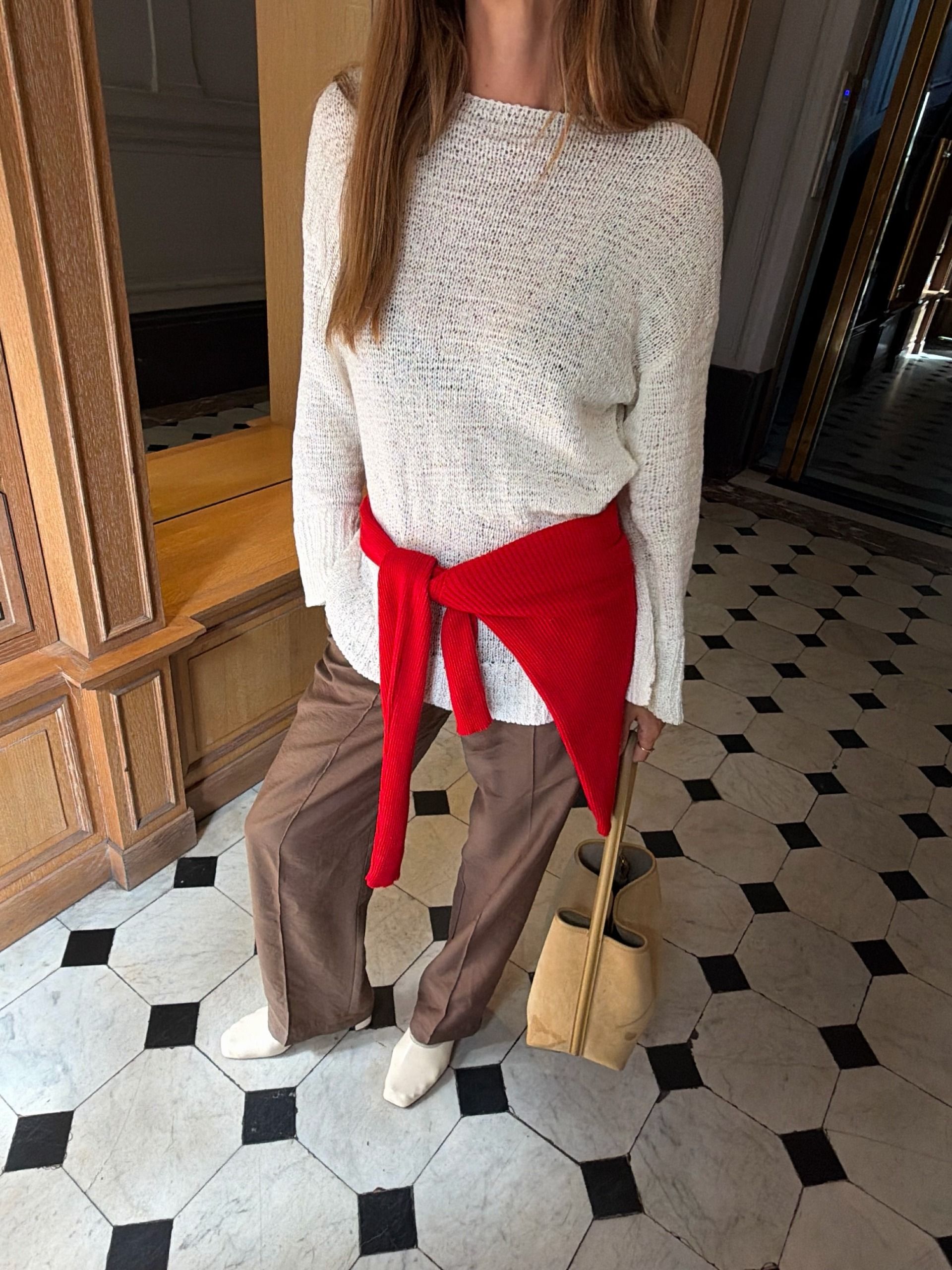 @annelauremais wearing a semi-shirt white swear, red cardigan, trousers, and white heels