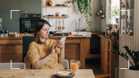 Connections News Piece - woman sat at table playing on her phone