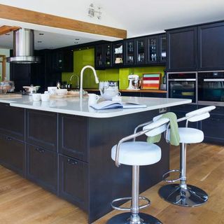 kitchen with white counter black cabinets and white chairs