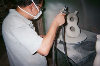 A man spray painting a figure eight bottle