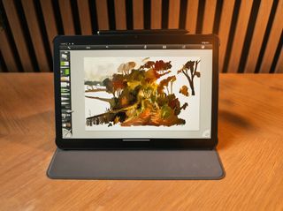 A black Android drawing tablet on a wooden table