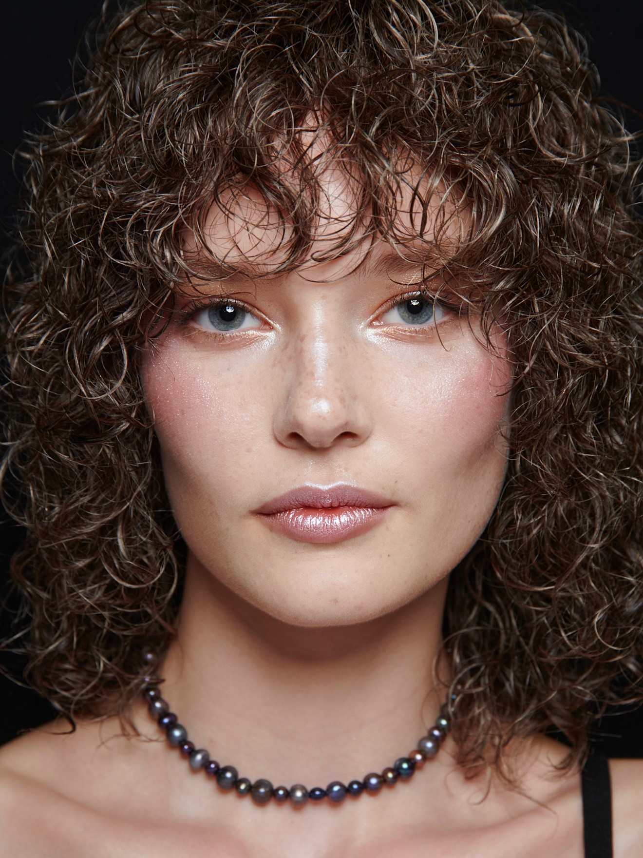 A model wearing a NYE-inspired makeup look complete with frosted lips and shimmery eyes.