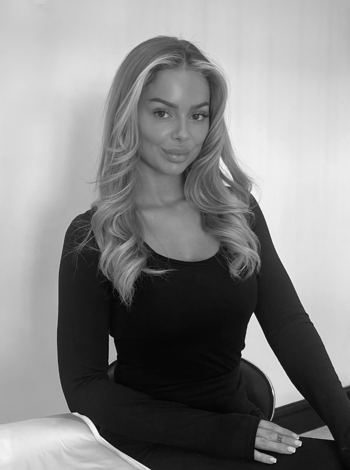 A black and white headshot of a woman smiling at the camera