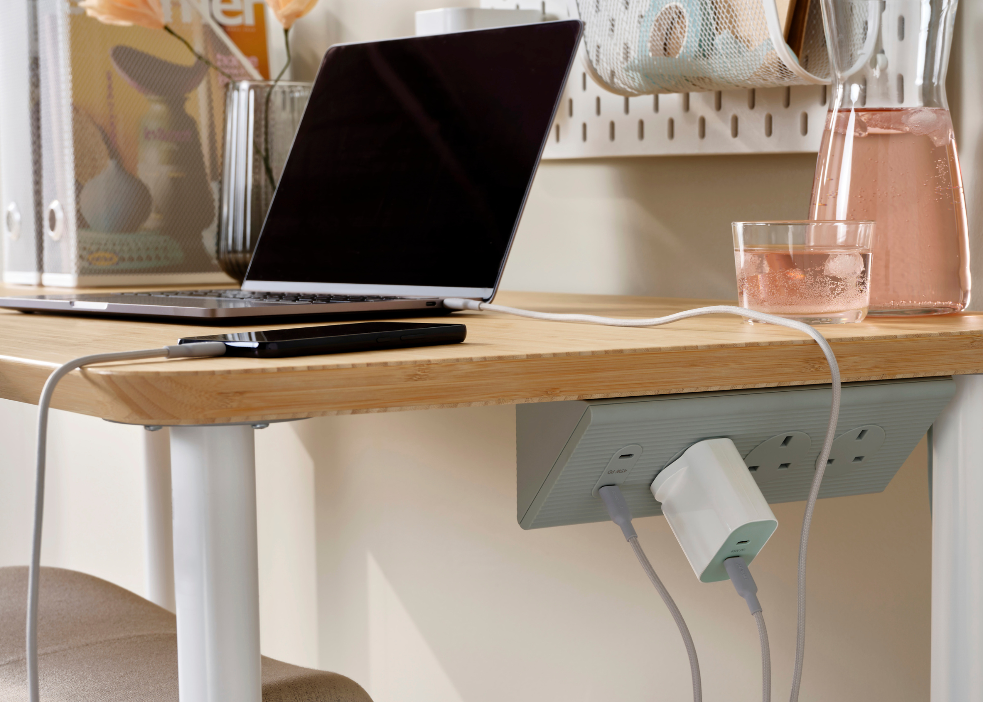 IKEA SKOTAT Extension cord in green positioned underneath a home office desk