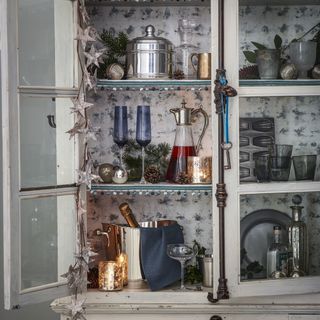 white cabinet with glasses jar bottles and cups