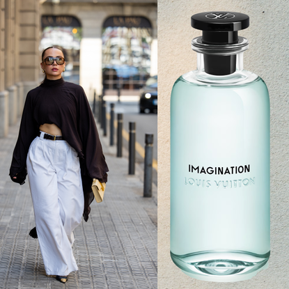 A woman wearing a brown long sleeve top and white pants with a low ponytail and sunglasses. She is next to a bottle of perfume. 