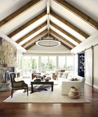 neutral living room with high ceiling and wooden beams