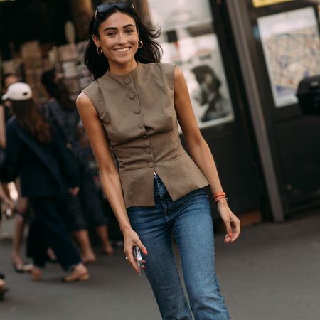 Fashion week attendee wearing a brown vest top and jeans 
