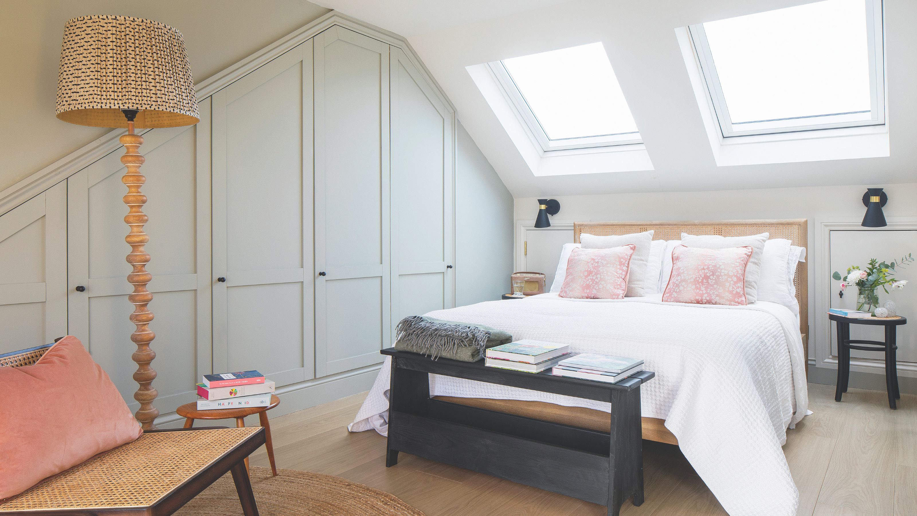 Loft bedroom with fitted wardrobes on the left of the and a bed in the middle