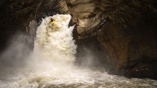 A kayaker in a powerful waterfall