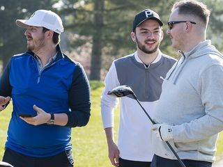 Three golfers having a discussion on the tee box