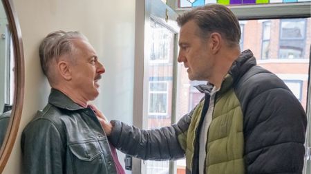David Morrissey pushes Alan Cumming against a hallway wall
