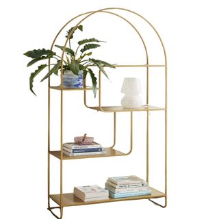 Gold semi-oval bookshelf with books and plants and decor