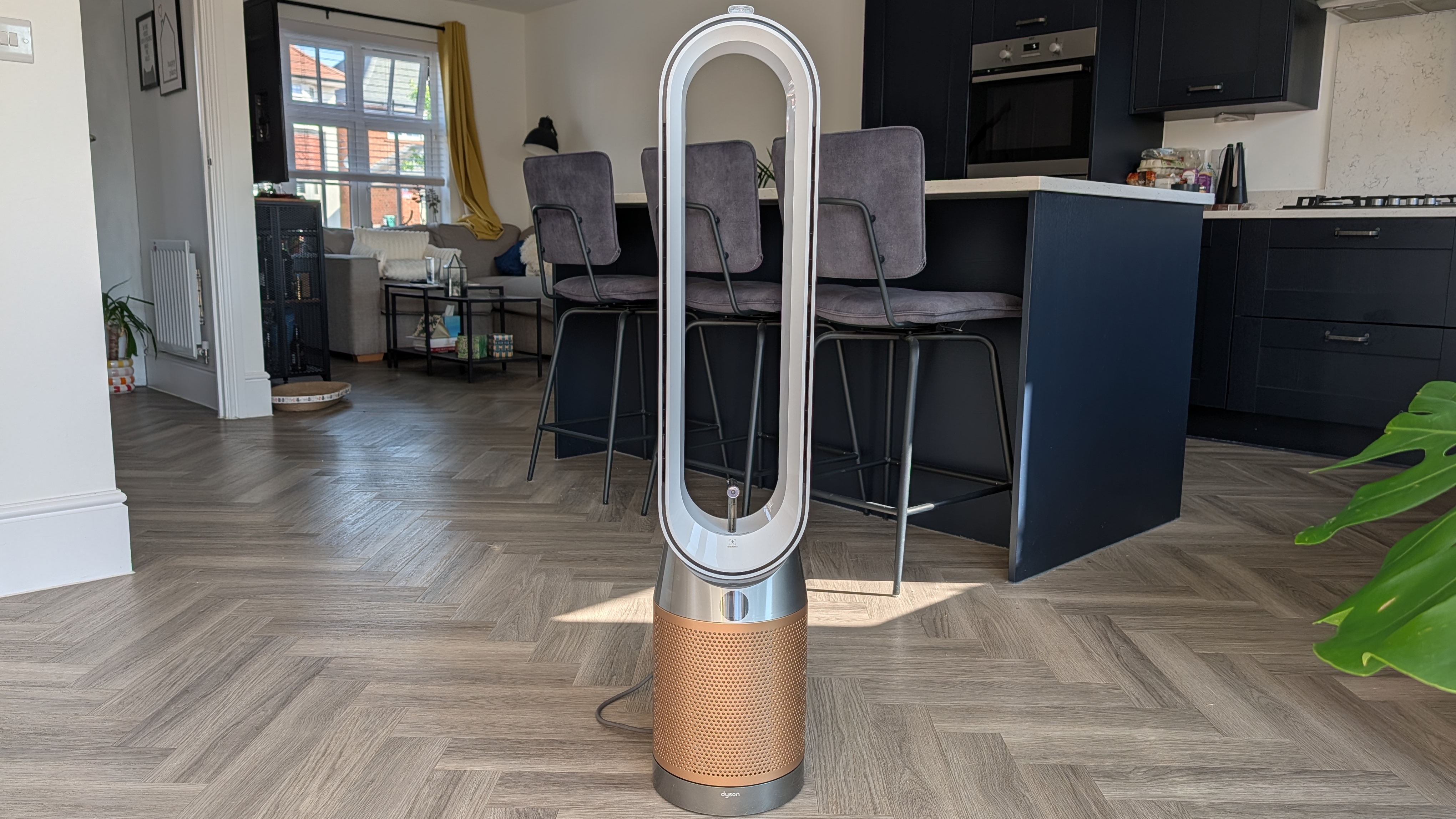 The Dyson Find+Follow Purifier Cool standing in someone's kitchen.