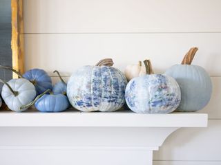 blue painted pumpkins and gourds on a mantel
