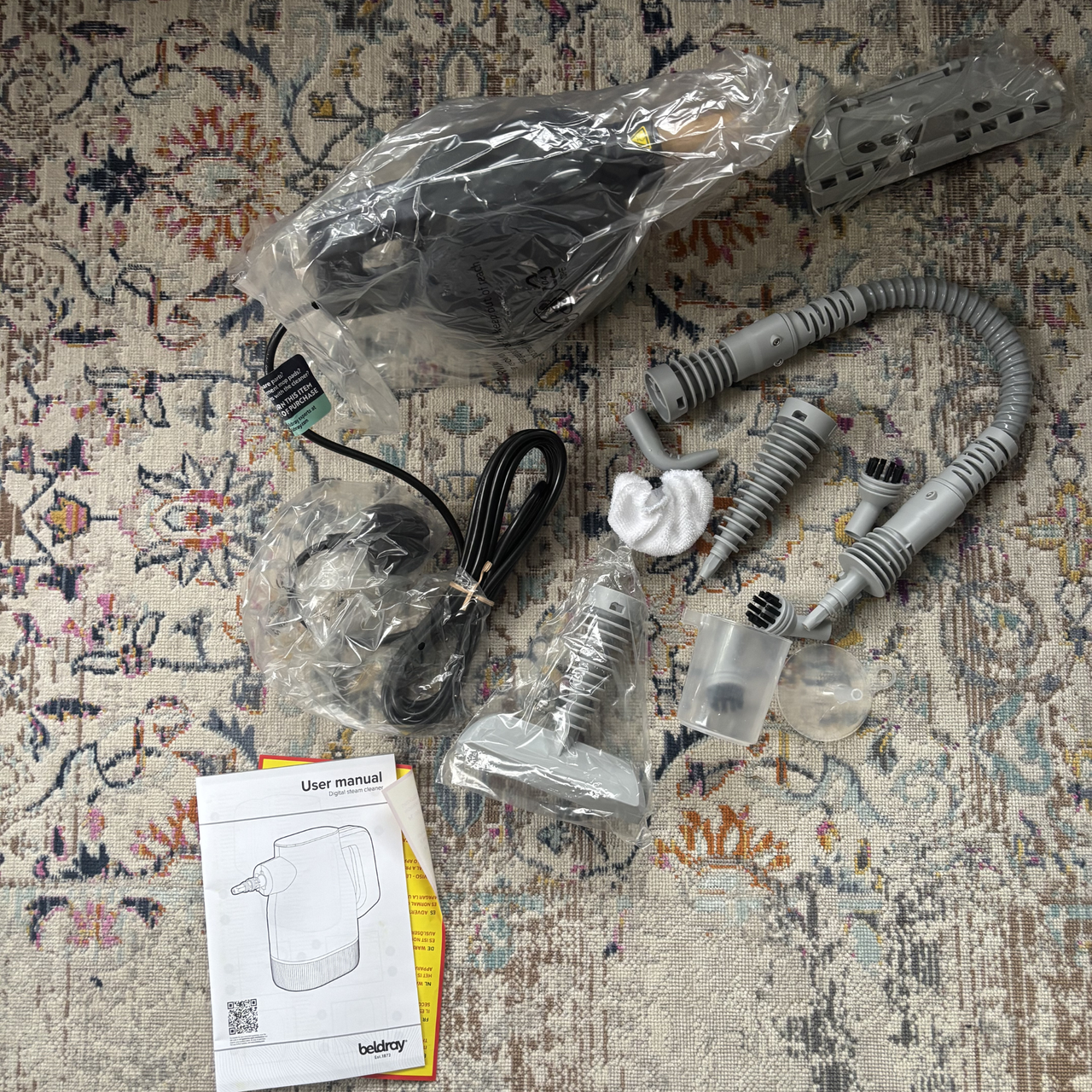 Beldray Digital Handheld Steam Cleaner parts and accessories wrapped in plastic packaging