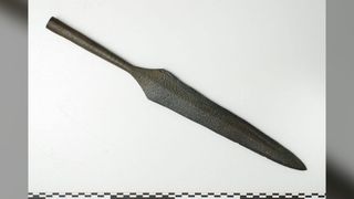 an iron spearhead pictured against a white background