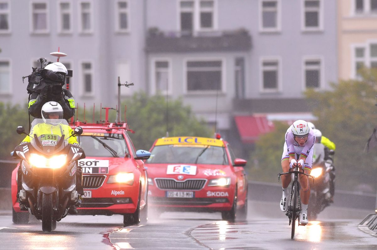 Tony Martin is followed by two cars and a moto during his TT