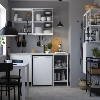 grey kitchen with wall cupboards and small table and storage options