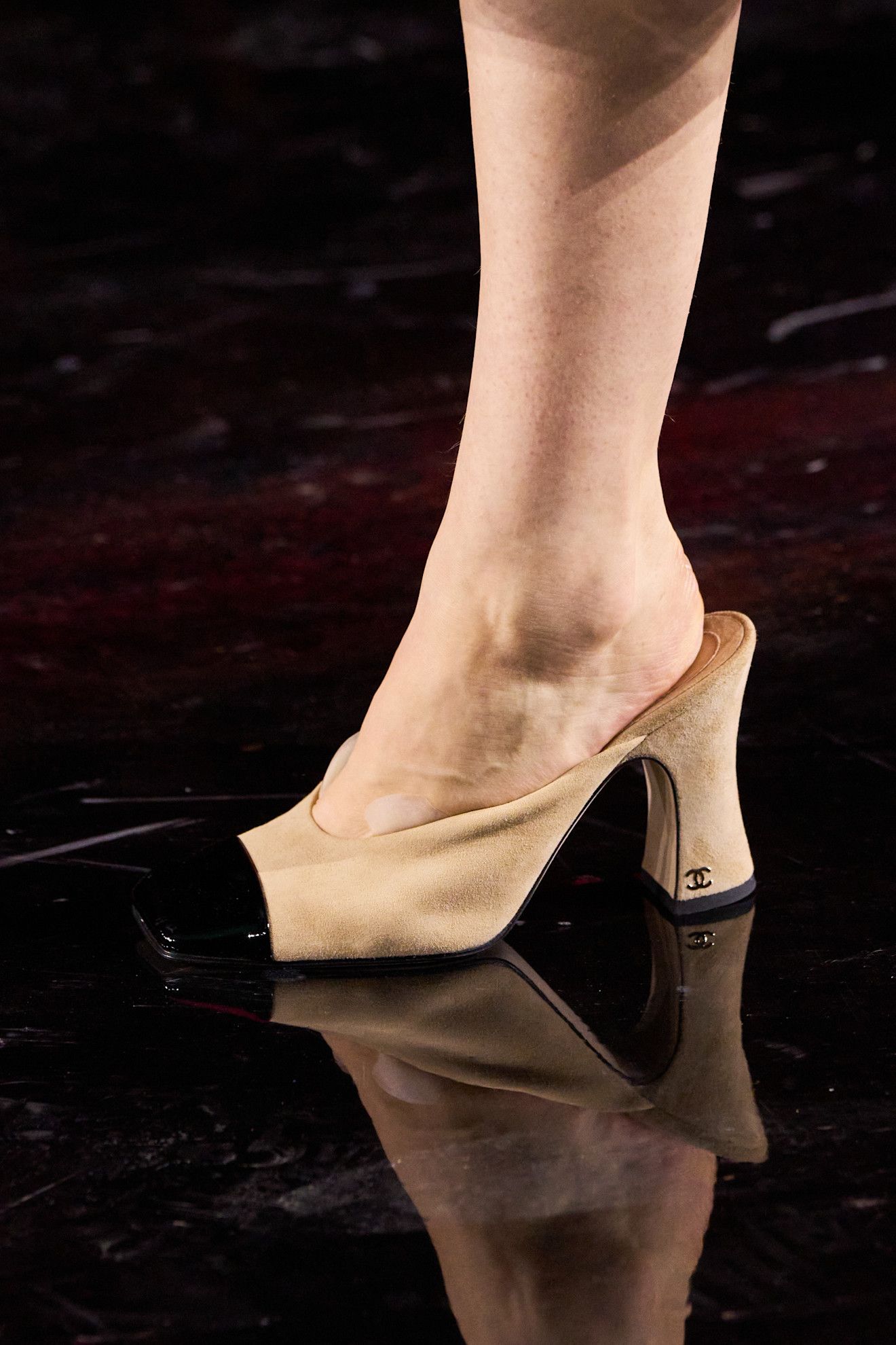 A model at the spring/summer 2026 show for Chanel wearing two-tone mules.