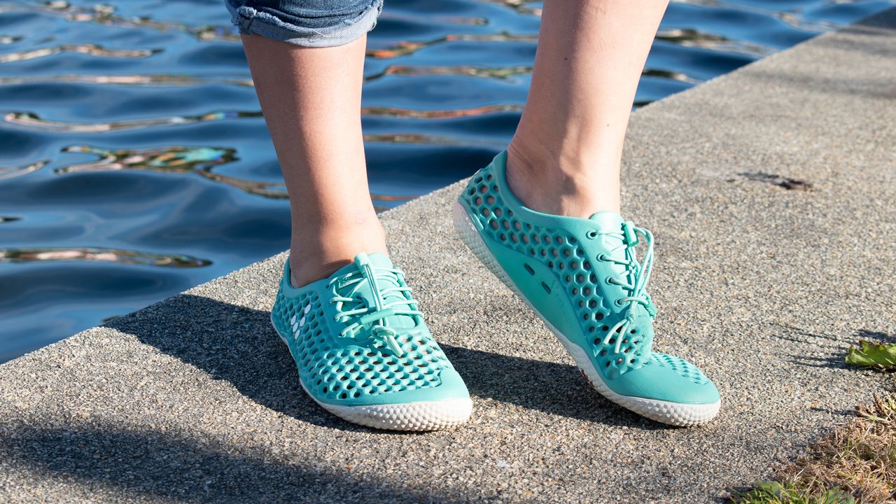 Person wearing Vivobarefoot Ultra Bloom III water shoes on waterside