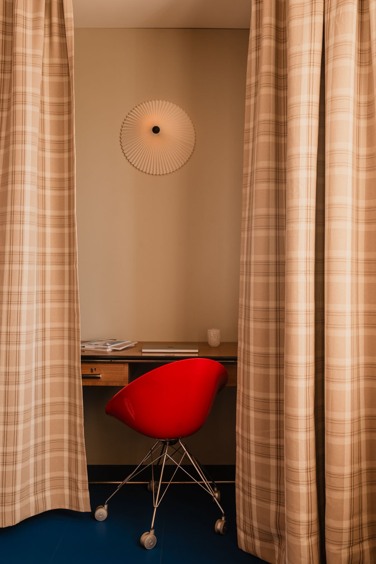 Images of a Warsaw apartment, where curtains help delineate a desk area as well as a sleeping nook.