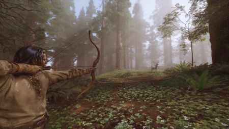 Long-haired man aims drawn bow toward deer standing at a distance in a foggy forest