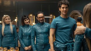 The cast of "Billionaires Bunker" cast in their blue jumpsuits in a scene from the Netflix show