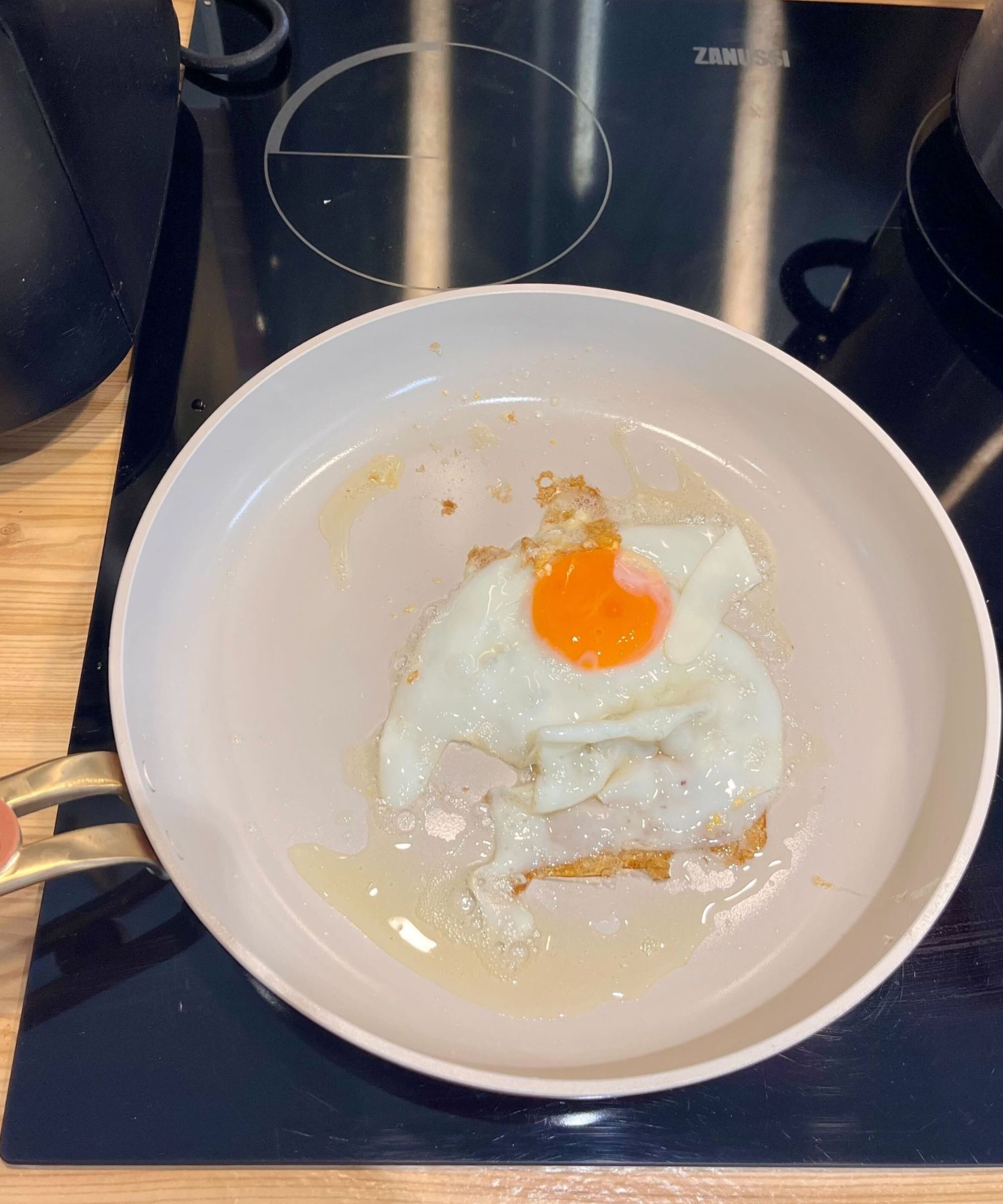 Frying an egg in the Our Place frying plan from the Essentials 11-Piece Set. The edges are crispy, and the egg is intact with a semi-runny yolk.