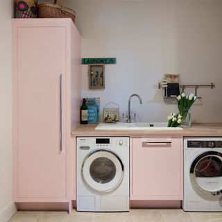 kitchen with white wall pink cabinet and wash basin