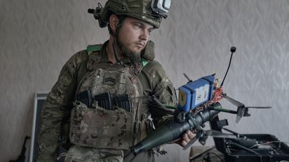 A soldier holds a drone