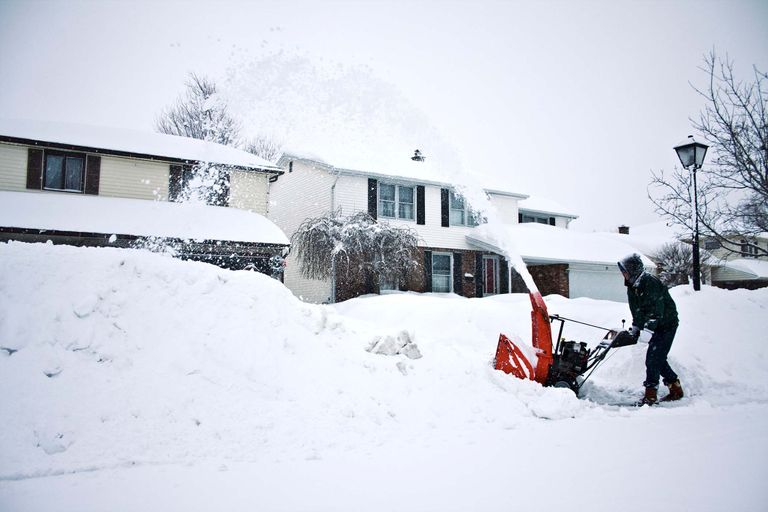 one of the best snow blowers in front of a home during a snowstorm