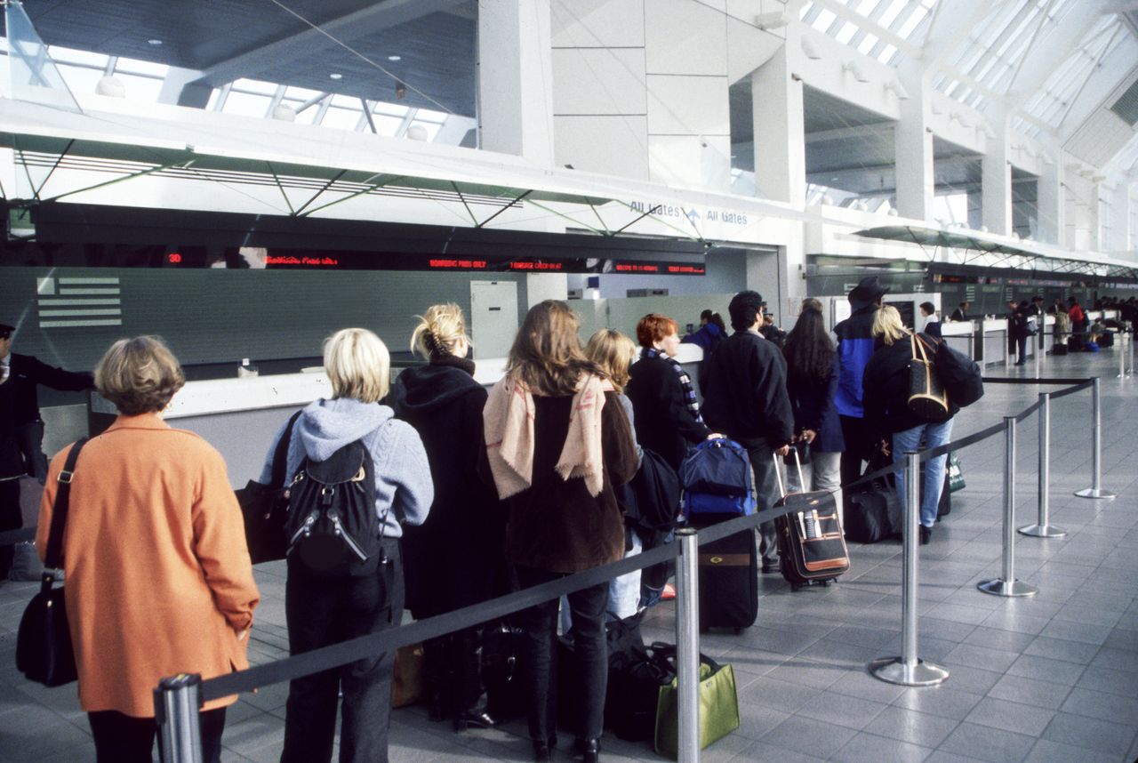 Long line of people with suitcases at the airport.