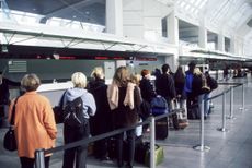 Long line of people with suitcases at the airport.