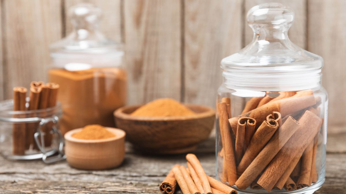 Cinnamon sticks in glass jars and ground cinnamon in bowls