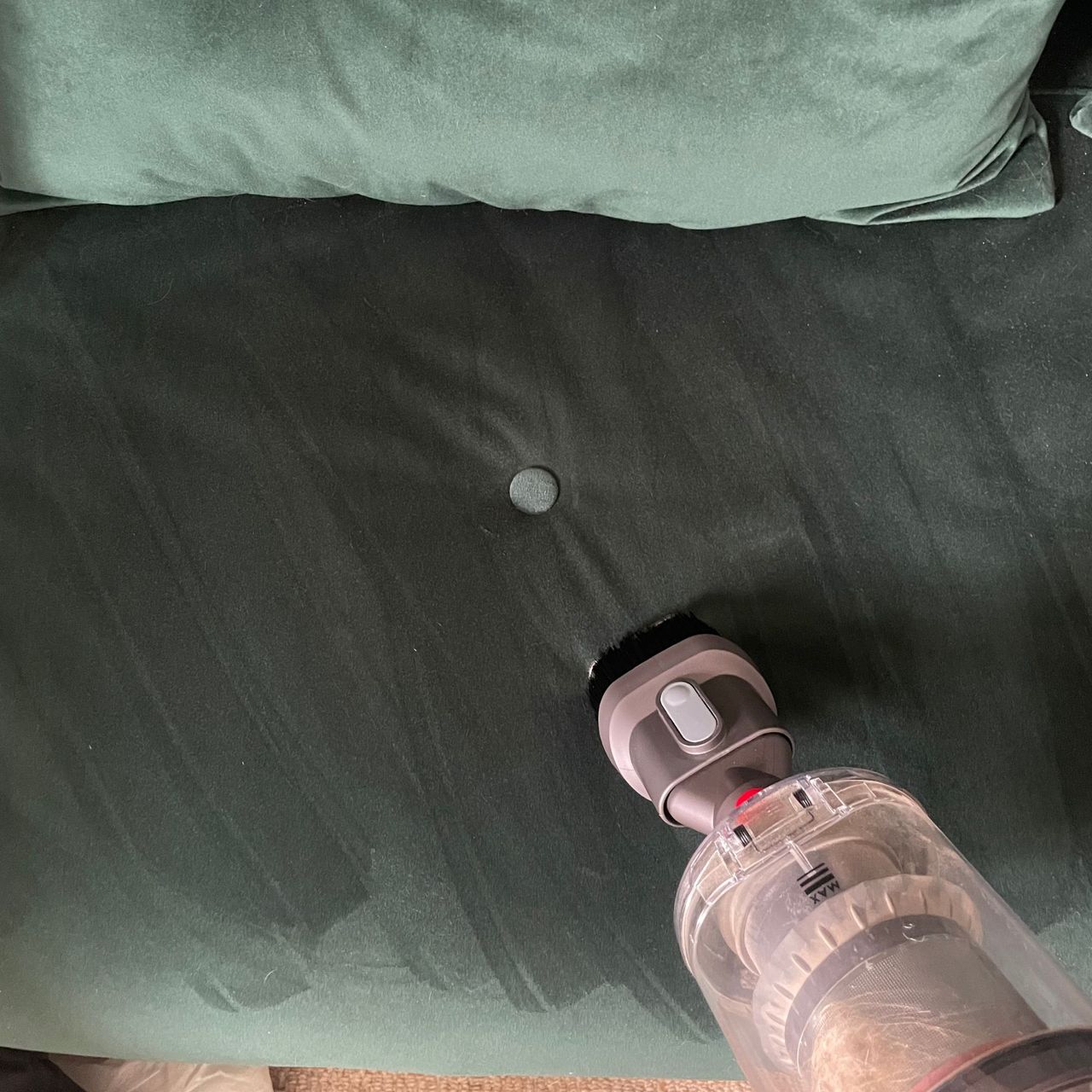 A clean green sofa bed with visible cleaning lines after using the combination tool