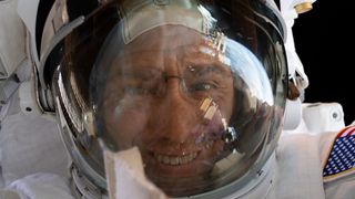 a man in a spacesuit is smiling