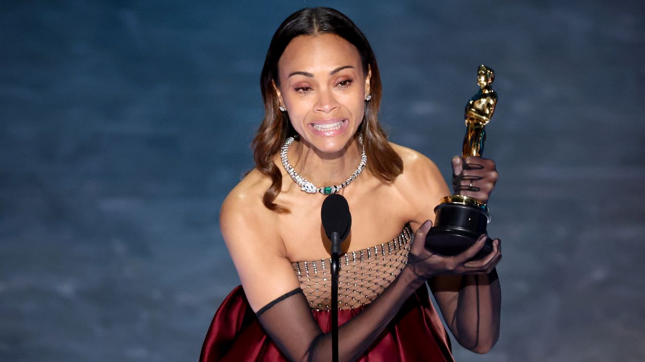 Zoe Saldaña accepts the award for Best Supporting Actress at the 2025 Oscars.