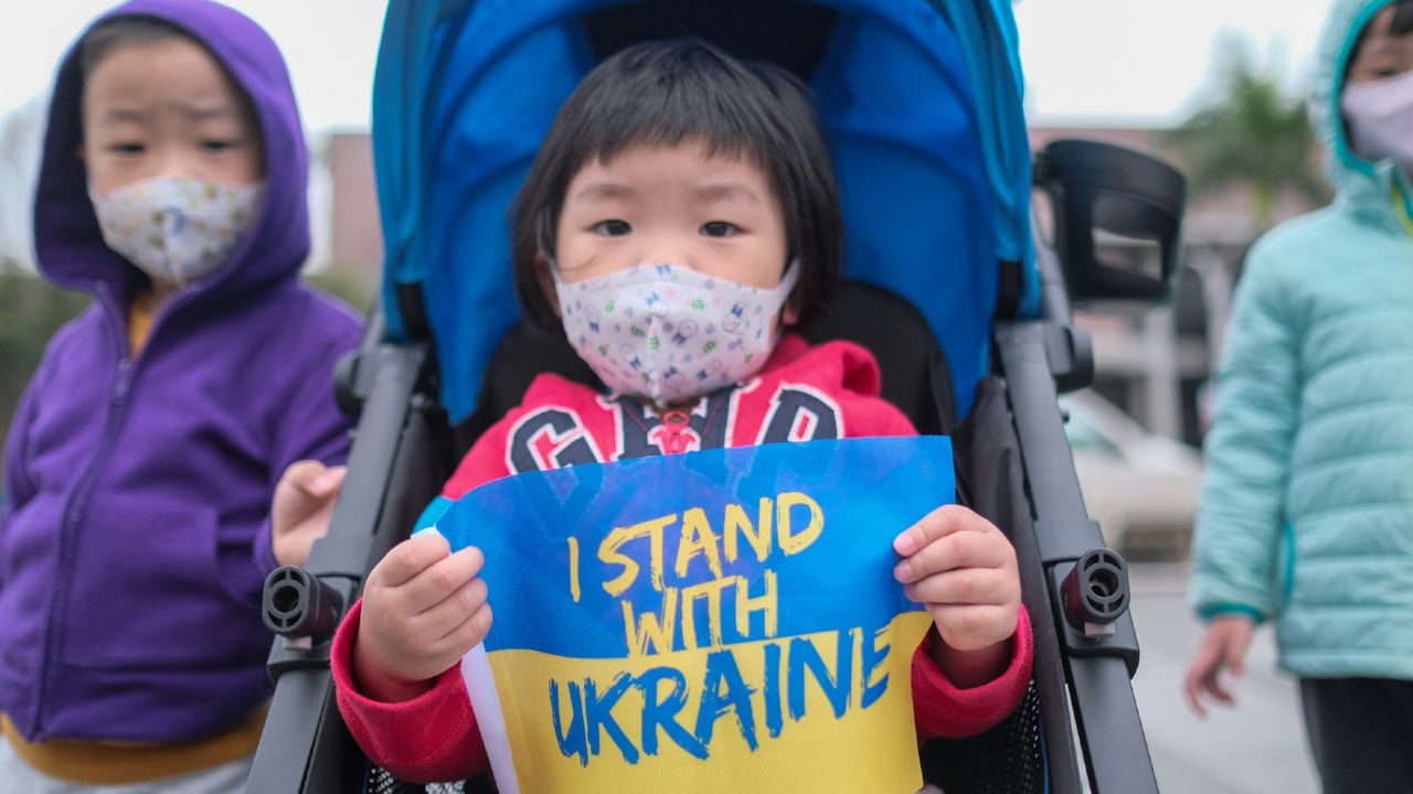 Child holding &amp;#039;I stand with Ukraine&amp;#039; poster