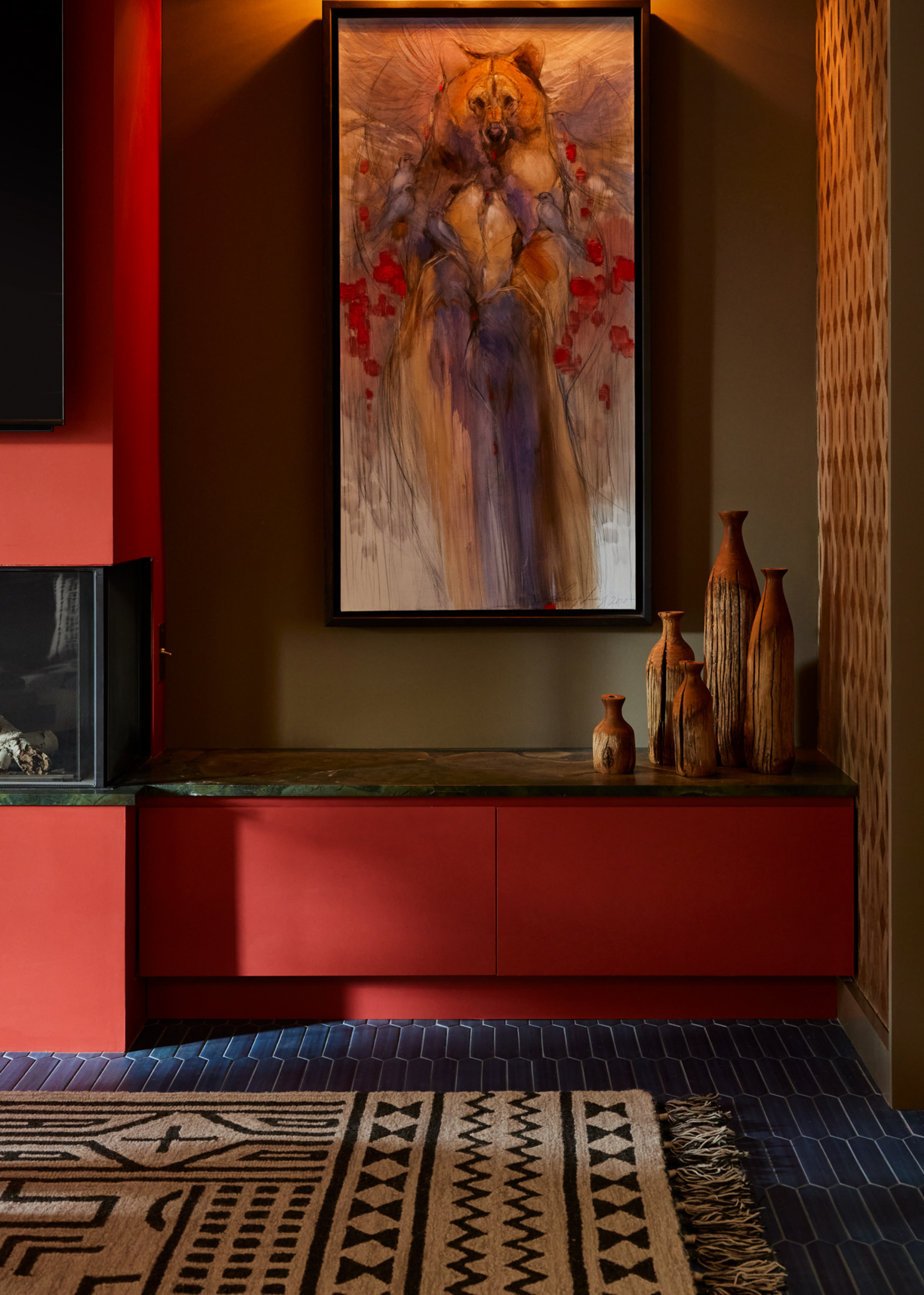A living room with a blue carpet and an earthy rug