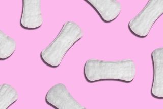 Several sanitary pad period products on a pink background