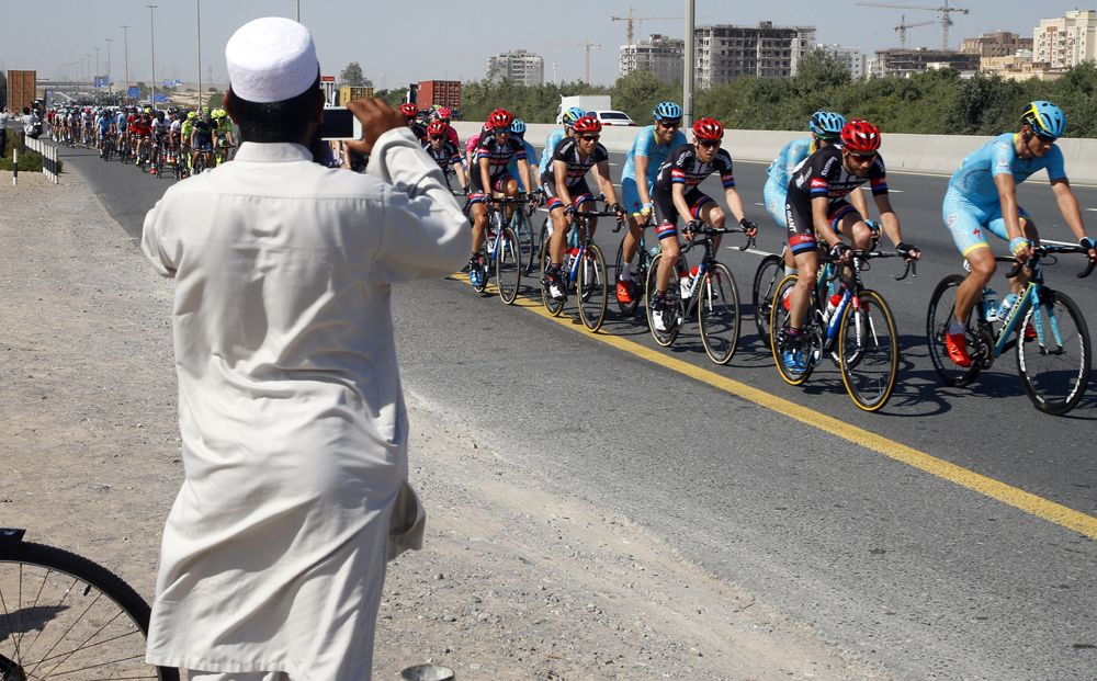 A local takes a photo of the passing riders