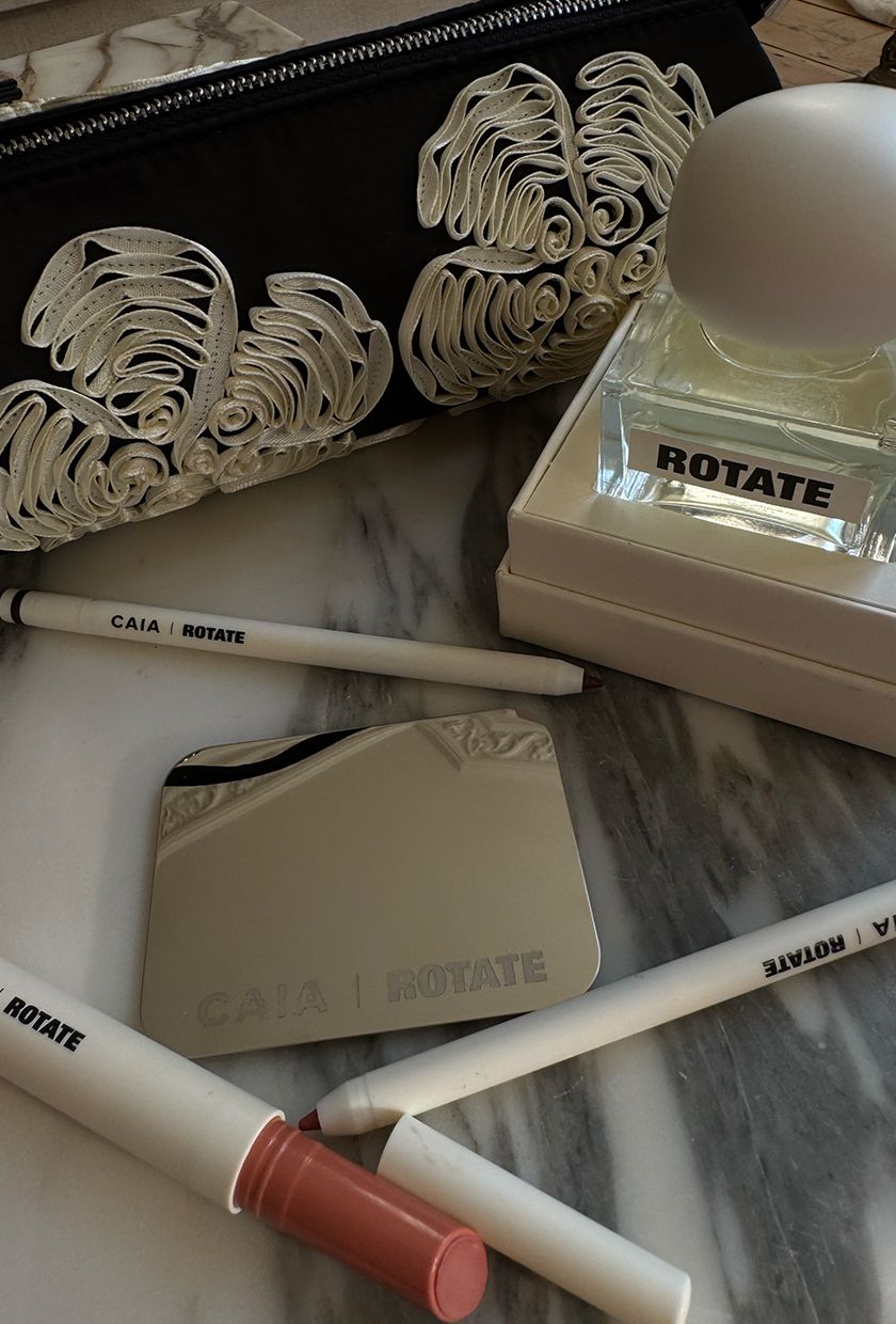 A flatlay of Caia x Rotate makeup products and perfume