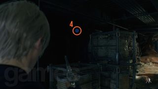 Resident Evil 4 Remake Cargo Depot blue medallion behind some crates, boxes, and cages