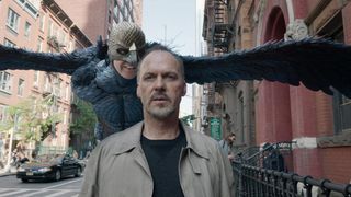 A still from the movie Birdman, one of October's new Hulu movies, showing Michael Keaton being followed down a street by a big bird