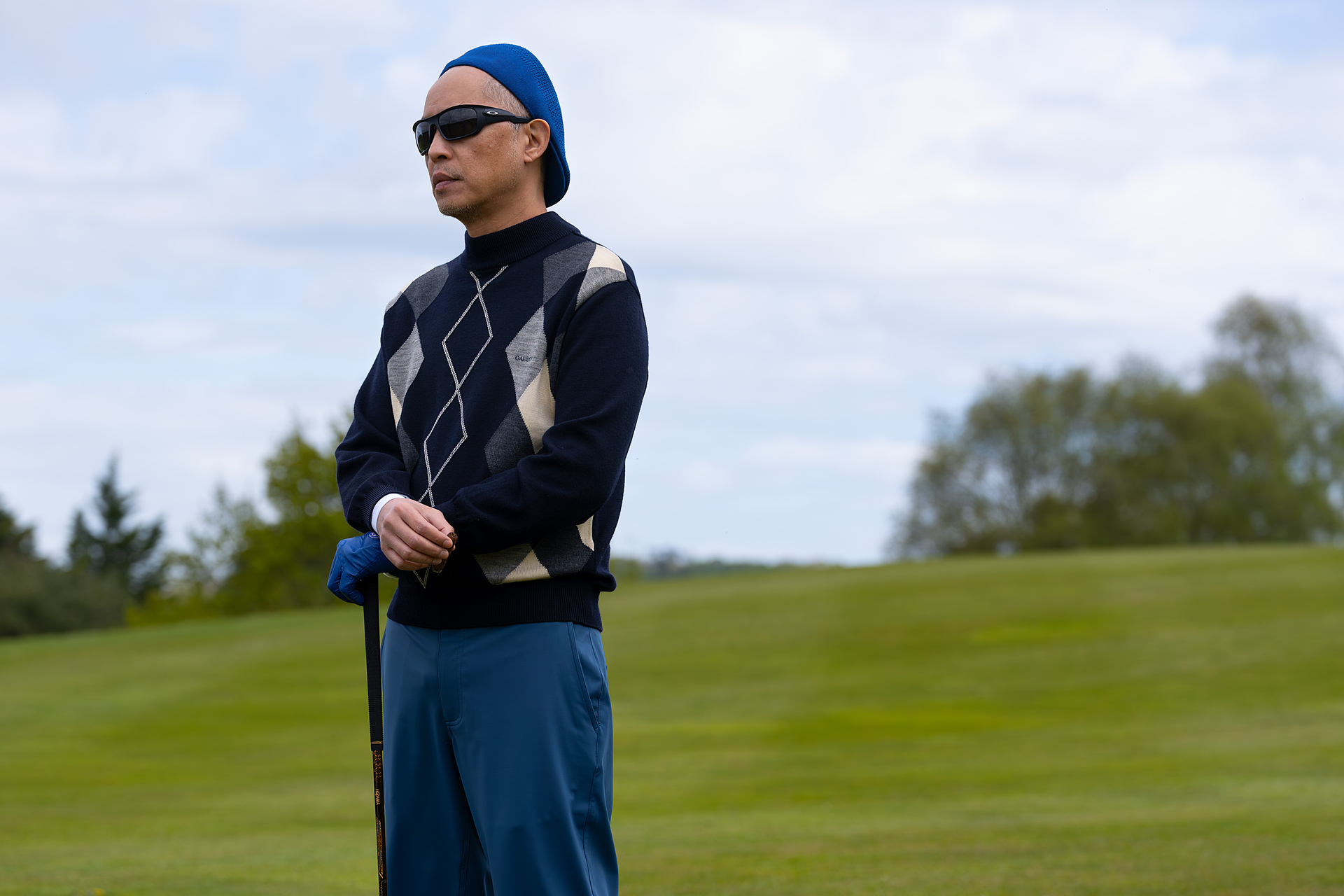 ken leung wearing golfing clothings on a green in industry season 4