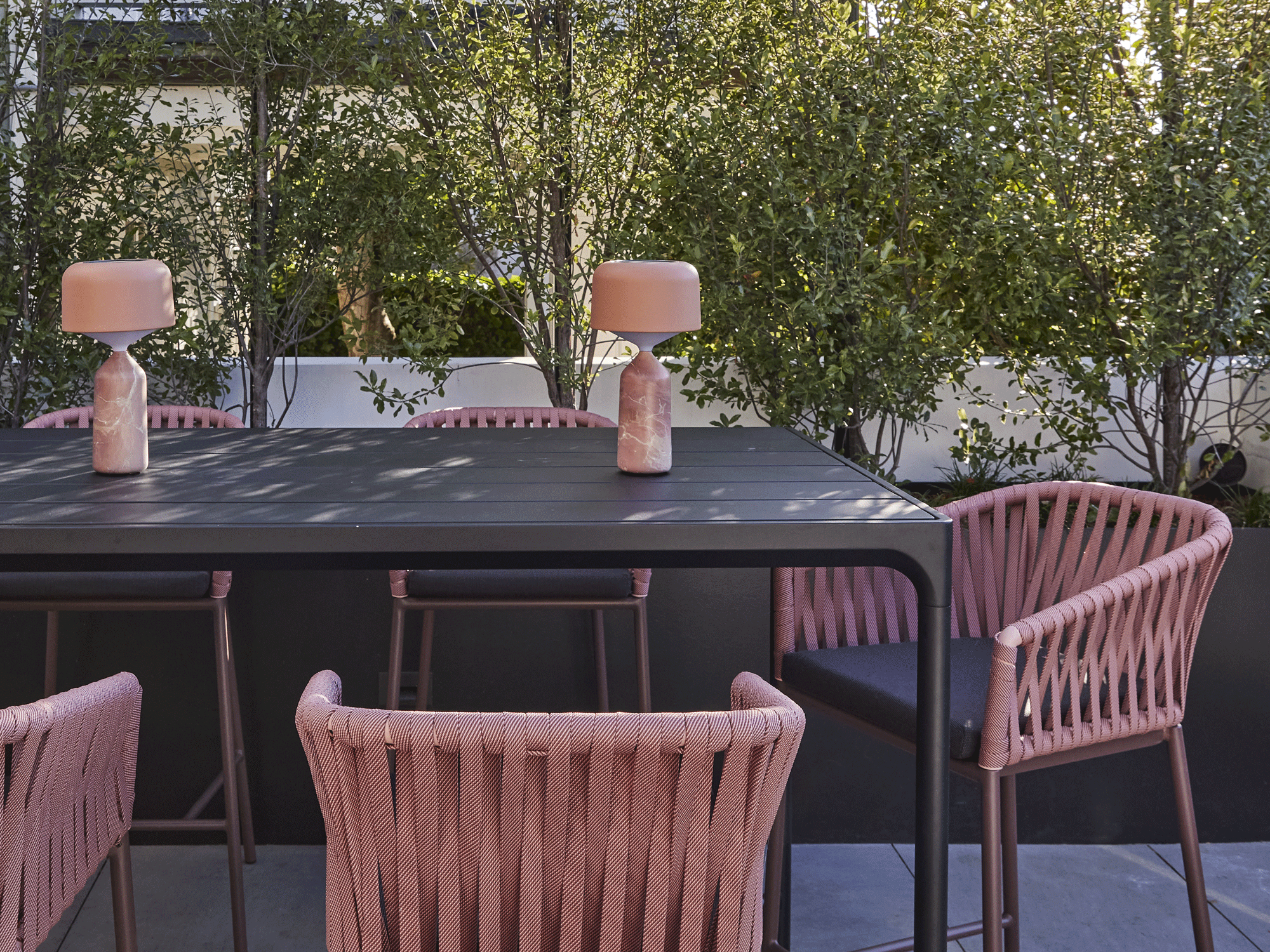 outdoor dining set with pink chairs and accessories