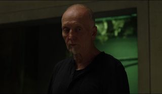 Tobin Bell stands very much alive in a room in Jigsaw.