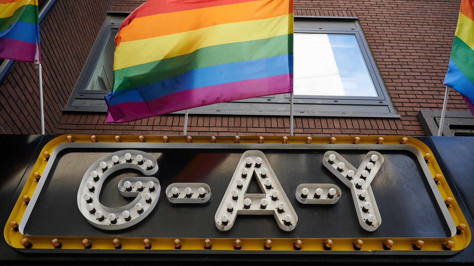 The G-A-Y Bar sign with a flag above it 