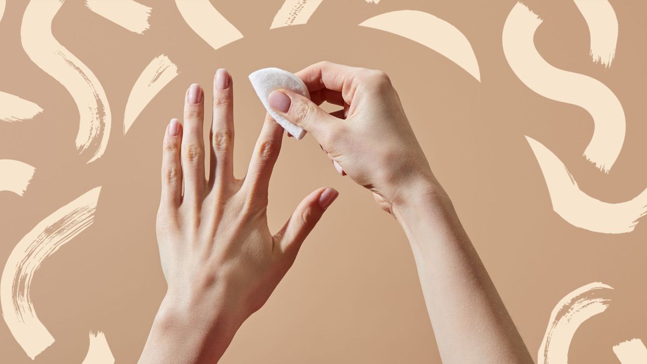 A womans hand using acetone on the nail, stage one of how to remove gel nails at home 